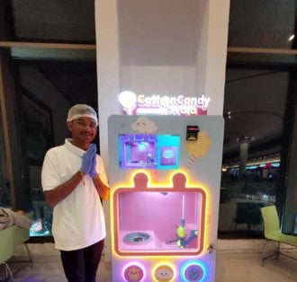 CottonCandyWala operator next to a cotton candy vending machine with a touch screen